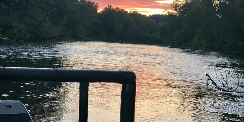 Sunset over a river on a boat used for sucker gigging