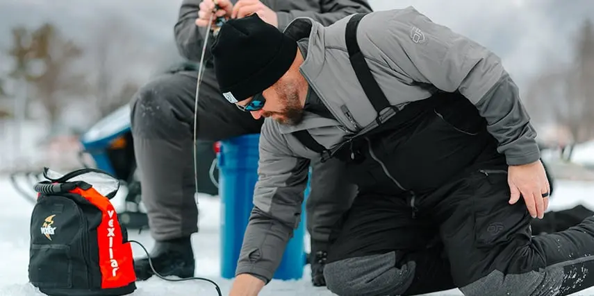 angler reaching into the water to pull out fish
